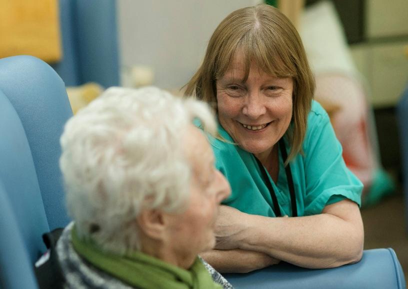 An older adult reviewing Medicare enrollment documents with an advisor.