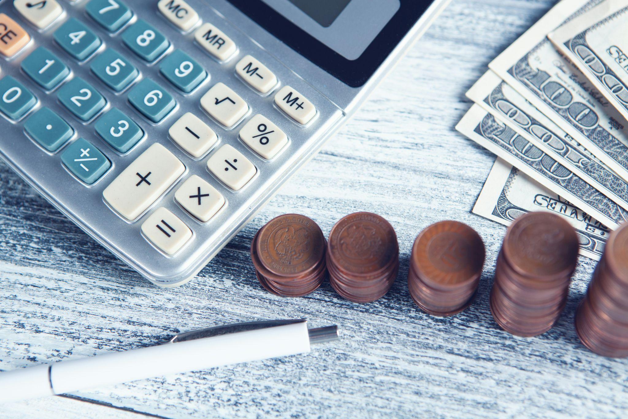 Calculator, cash, and coins representing budgeting for a California final expense program