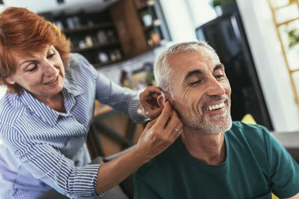 Senior happy about getting a hearing aid through hearing insurance for seniors in California.