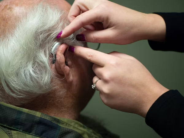 A senior man getting getting an hearing aid support with hearing insurance for seniors in California