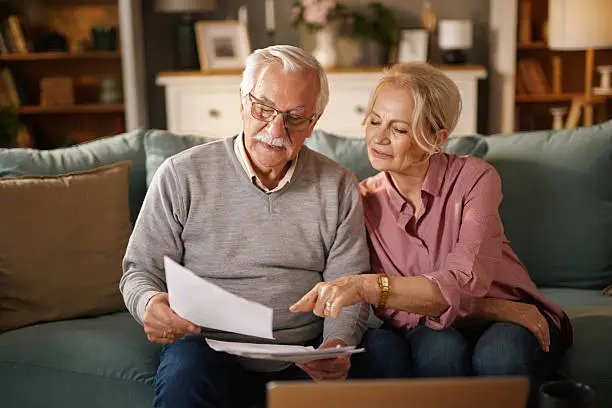 Older couple reviewing permanent life insurance documents and financial planning options.