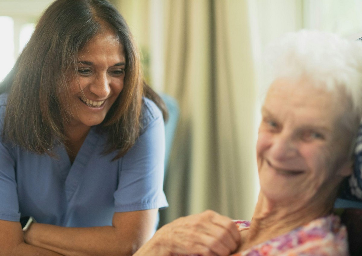Caregiver assisting a woman with long term care insurance for seniors in California